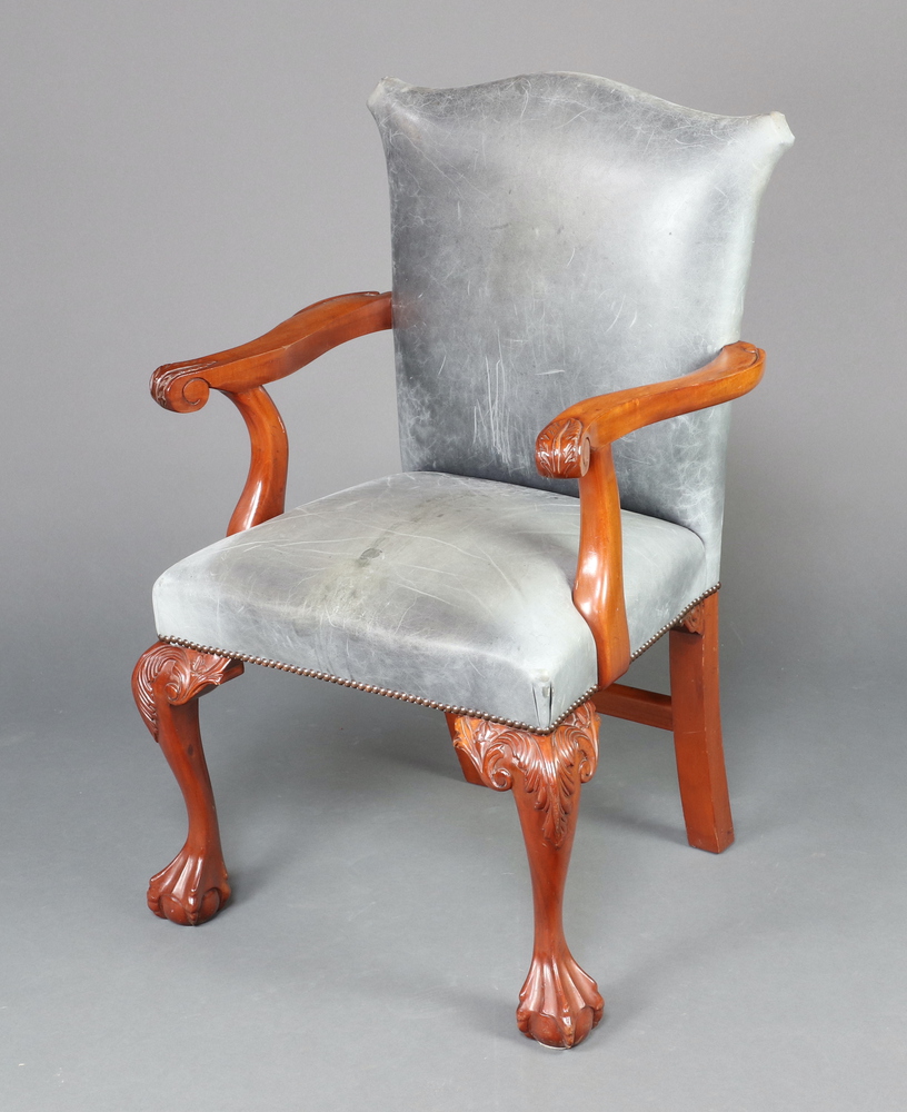 A Georgian style carved mahogany open arm library chair, the seat and back upholstered in blue