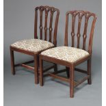 A pair of 19th Century mahogany stick and rail back chairs with upholstered drop in seats, on square