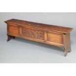 A 1930's 17th Century style oak coffer of panelled construction with hinged lid 49cm h x 152cm w x