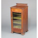 An Edwardian inlaid mahogany music cabinet with raised back inlaid musical trophies, fitted