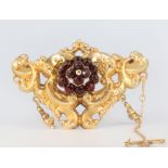 A Victorian yellow metal repousse brooch set with garnets 55mm x 40mm