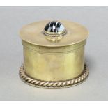 A brass cylindrical jar and cover the lid set a cabochon cut stone 6cm x 10cm