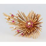 An 18ct yellow gold diamond and ruby starburst brooch, 55mm