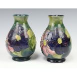 Moorcroft, a pair of green ground clematis pattern vases, the bases impressed Moorcroft Made in