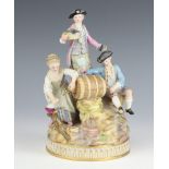 A Meissen group of revellers beside a barrel raised on a rocky base, underglaze blue mark to base