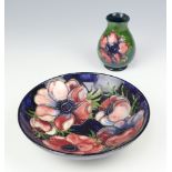 A William Moorcroft blue shallow dish decorated anemones monogram mark 18cm, a cream ground