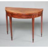 A Georgian crossbanded and inlaid mahogany D shaped card table raised on square tapered supports,