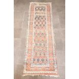 A brown, black and green ground Caucasian runner with all over geometric design within a 4 row