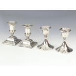 A pair of Edwardian design silver dwarf candlesticks on square bases, rubbed marks, 10cm and a ditto