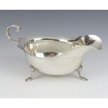An Edwardian silver sauce boat with cut rim, scroll handle and paw feet, Chester 1906, 146 grams