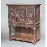 A Victorian carved oak cabinet with moulded cornice enclosed by a panelled door, carved medieval
