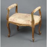 A 19th Century French gilt painted open arm dressing table stool with upholstered seat, raised on