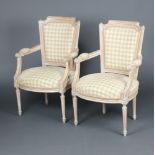 A pair of 18th Century style bleached wood open arm salon chairs, the seats and backs upholstered in
