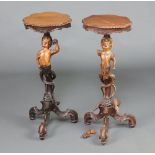 A pair of 19th Century carved limewood torcheres the tops of serpentine outline above figures of