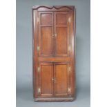 An 18th Century oak double corner cabinet with moulded cornice, both sections enclosed by panelled