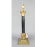 A gilt and black painted metal reeded standard table lamp with Corinthian column capital and stepped