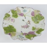 A Chelsea oval dish circa 1755 moulded vinery and grapes the centre decorated painted flowers,