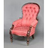 A Victorian mahogany show frame armchair upholstered in red floral material, the seat of