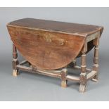 A Victorian 17th Century style oval elm drop flap gateleg dining table, raised on cup and cover
