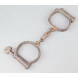 A pair of 19th Century iron handcuffs complete with key marked 4Hiatt