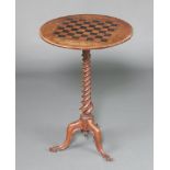 A Victorian circular inlaid walnut games table inlaid a chessboard, raised on spiral turned column