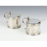 A near pair of Georgian design mustards with shell thumb pieces, spoons and blue glass liners,