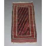 A red, white and blue Afghan rug, the central field with hooked medallions within a multi row border