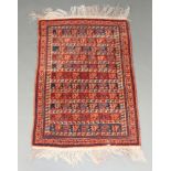 A black and orange ground Afghan rug decorated stylised animals within a 3 row border 128cm x 87cm