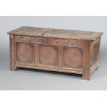 A mid 17th Century carved oak coffer of panelled construction with carved lunettes to the front