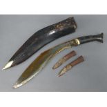 A Kukri with 30cm blade and horn grip, 2 skinning knives and leather scabbard