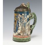 A German ceramic stein with metal lid, the body decorated with a townscape having a dragon handle