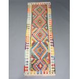 A white, green and turquoise ground Chobi Kilim runner with diamond decoration to the centre 247cm x