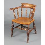 A 19th Century elm smoker's bow elbow chair raised on turned supports with H framed stretcher,