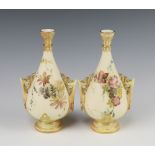A pair of Victorian Royal Worcester blush ivory and rose decorated twin handled vases, the bases