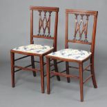 A pair of Edwardian inlaid mahogany bedroom chairs with tracery backs and upholstered seats raised