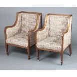 A pair of Edwardian mahogany show frame wing armchairs upholstered in tapestry material, raised on