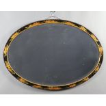 A 1930's oval bevelled plate wall mirror contained in a black lacquered chinoiserie style frame 56cm