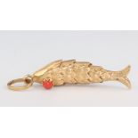 A yellow metal stamped 18 articulated fish pendant with coral eyes 5.7 grams, 40mm