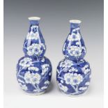 A pair of Chinese prunus pattern double gourd shaped vases, bases with 4 character mark 20cm