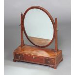 A 19th Century oval plate dressing table mirror contained in a mahogany frame on a rectangular