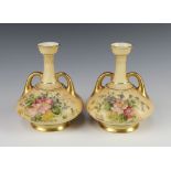 A pair of Victorian Royal Worcester blush ivory twin handled vases of squat form, the bases with