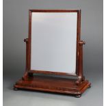 A Victorian rectangular plate dressing table mirror contained in a mahogany swing frame, raised on