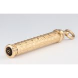 A yellow metal engine turned propelling pencil with hardstone engraved monogram, gross weight 21.8
