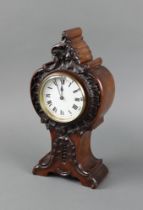 A 19th Century French timepiece with 8cm enamelled dial, Roman numerals, contained in a carved