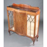 A 1930's Chippendale style mahogany bow front display cabinet with raised back, cupboard enclosed by