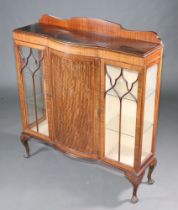 A 1930's Chippendale style mahogany bow front display cabinet with raised back, cupboard enclosed by