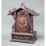 A Swiss cuckoo clock with Roman numerals contained in a carved wooden case 56cm h x 35cm w x 22cm d,