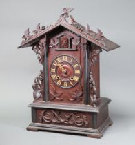 A Swiss cuckoo clock with Roman numerals contained in a carved wooden case 56cm h x 35cm w x 22cm d,