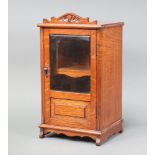 A light oak smokers cabinet fitted a drawer enclosed by bevelled plate panelled door on shaped