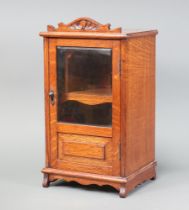 A light oak smokers cabinet fitted a drawer enclosed by bevelled plate panelled door on shaped